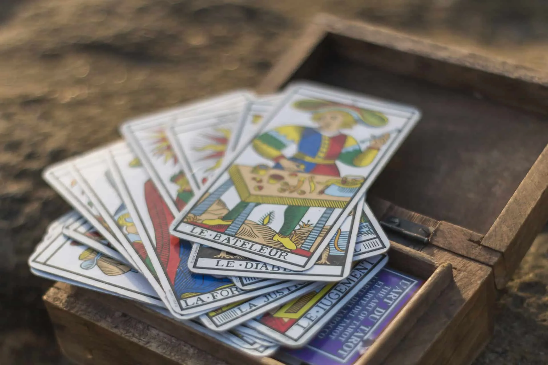 Cartas do Tarot de Marselha espalhadas sobre uma caixa de madeira