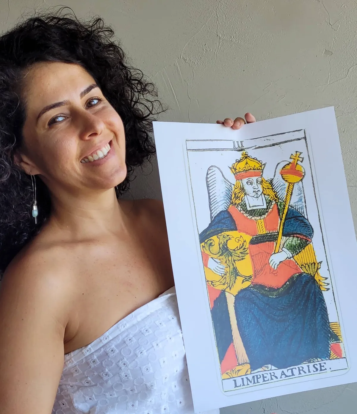Jacqueline Lima sorrindo e segurando a carta A Imperatriz do Tarot de Marselha